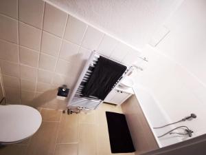 ein Bad mit einem WC und einem schwarzen Handtuch in der Unterkunft Zentral und ruhig in Chemnitz in Chemnitz
