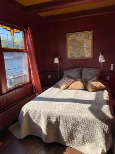 a bedroom with a bed and a window at Houseboat Amstel River Studio in Amsterdam