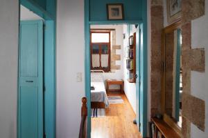 um corredor com uma porta azul e uma mesa num quarto em Lindas Convent Garden Home 4 em Chania