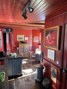 a room with red walls and a kitchen with a counter at Houseboat Amstel River Studio in Amsterdam