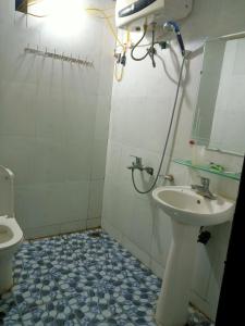 a bathroom with a sink and a toilet and a mirror at Triệu Chương Homestay in Cao Bằng