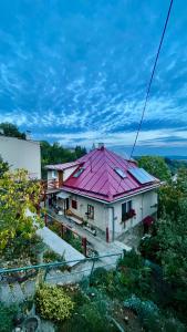 a house with a pink roof on top of it at Apartmán Franko in Banská Štiavnica