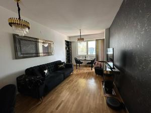 een woonkamer met een zwarte bank en een tafel bij Royal Casa in Skopje