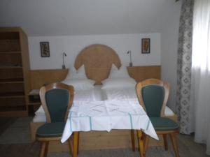 a dining room table with two chairs and a white table at Haus Waidmannsheil in Mayrhofen