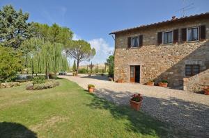 una casa de piedra con un patio delante en Villa Cassia by PosarelliVillas, en Bagno Vignoni