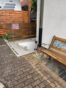 a wooden bench sitting next to a building with a wood fence at Apartment 4you in Eggolsheim