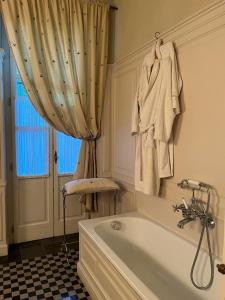 een badkamer met een bad en een douchegordijn bij Suite Vittorio Emanuele in Alba