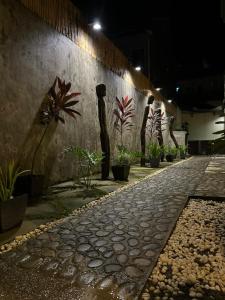 uma passagem de pedra com vasos de plantas numa parede em Bulul Garden Resort em El Nido