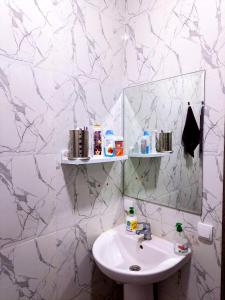 La salle de bains blanche est pourvue d'un lavabo et d'un miroir. dans l'établissement la casa bella 5 minutes de la plage, à Essaouira