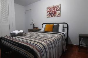 Un dormitorio con una cama con una manta a rayas. en Casa Rosairis 