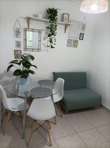uma sala de jantar com uma mesa e um sofá verde em Santa Bárbara em Alicante