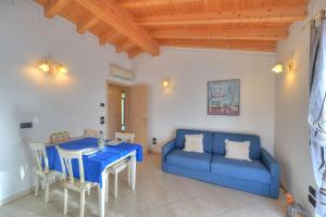 ein Wohnzimmer mit einem blauen Sofa und einem Tisch in der Unterkunft Agriturismo L'Uliveto in Gargnano