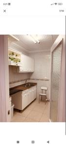 a kitchen with white cabinets and a chair in it at Santa Bárbara in Alicante