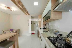 uma cozinha com um lavatório e um fogão forno superior em AP PRAIA DE CANASVIEIRAS ÓTIMA LOCALIZAÇÃO em Florianópolis