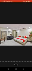 einen TV-Bildschirm mit einem Schlafzimmer mit einem Bett und einem Sofa in der Unterkunft HOTEL SURYAKANT in Rajkot