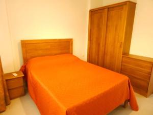 a bedroom with an orange bed and a wooden cabinet at Amazing 2 bedrooms with garden in Quatre Bornes