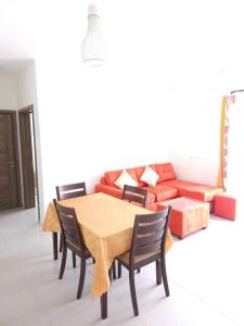 a dining room with a table and a couch at Amazing 2 bedrooms with garden in Quatre Bornes