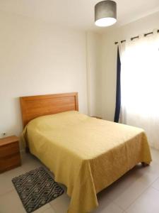 a bedroom with a bed with a yellow blanket on it at Amazing 2 bedrooms with garden in Quatre Bornes