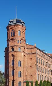 a brick building with a tower on top of it at Studio Mały Rynek in Żyrardów