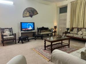 a living room filled with furniture and a flat screen tv at Urban Lodge in Abbottabad