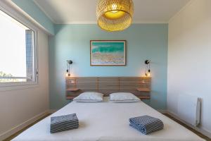 1 dormitorio con 1 cama blanca grande y 2 almohadas en Vue sur mer La Baule Moana en La Baule