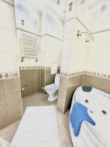 een badkamer met een groot bad en een toilet bij Mega Tower Almaty with beautiful moutain views in Alma-Ata