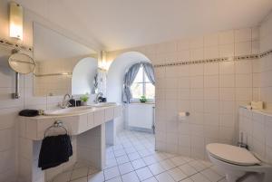 a white bathroom with a toilet and a sink at Kaštieľ Sokoľany 