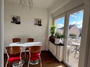 een eetkamer met een tafel en stoelen en een balkon bij Gästezimmer Limburg City in Limburg an der Lahn