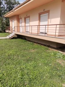 a house with a balcony and a grass yard at Cozy Nook Cottage in Faneroméni