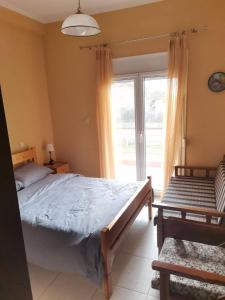 a bedroom with a bed and a large window at Cozy Nook Cottage in Faneroméni