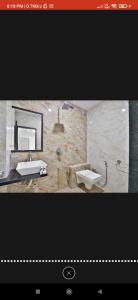 a bathroom with a sink and a mirror at HOTEL SURYAKANT in Rajkot +12 photos
