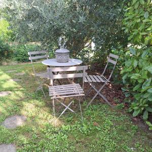 a picnic table and two chairs in a yard at Studio maxi 3 pers, acces H24, proche gare pour Paris in Sainte-Geneviève-des-Bois