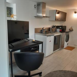 a kitchen with a black desk in a room at Studio maxi 3 pers, acces H24, proche gare pour Paris in Sainte-Geneviève-des-Bois