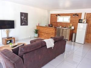 un soggiorno con divano e cucina di Le chal'heureux a Chirongui