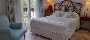 a bedroom with a bed and a chair and a window at miKasa Agua Amarga & SPA in Agua Amarga