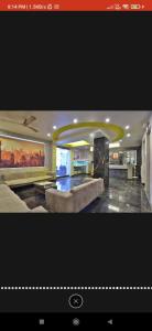 HOTEL SURYAKANT في راجكوت: غرفة معيشة كبيرة مع أريكة في منزل