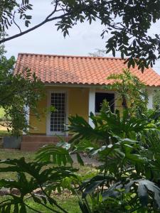 uma pequena casa amarela com um telhado vermelho em Pousada Recanto da Mata em Cavalcante