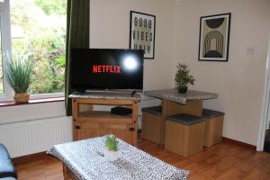 uma sala de estar com televisão numa mesa em Large 7 double bedroom house with large driveway em Earlham