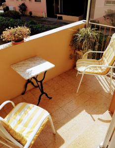 um par de cadeiras e uma mesa na varanda em La Victoire em Fréjus