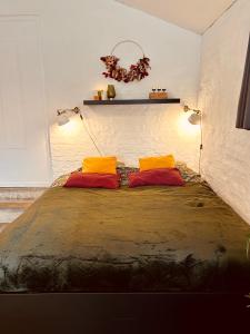ein Bett mit zwei orangenen Kissen in einem Zimmer in der Unterkunft Ké dodo sous le château !!! in Spa