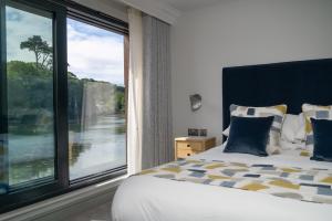 um quarto com uma cama e uma grande janela em The Shipwrights Arms em Helford
