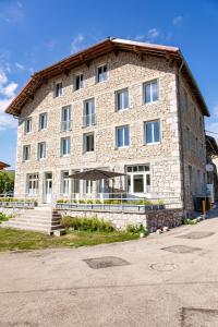 a large stone building with stairs in front of it at LA BATISSE l'arbre beige in Le Grand-Abergement