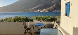 a balcony with a table and chairs and a view of the water at Aegean Dream Room in Kamares