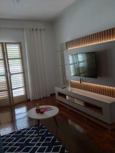 uma sala de estar com uma televisão e uma mesa de centro em Casa no Centro de São Lourenço em São Lourenço