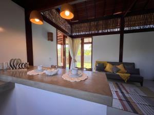 Pequena Lua Flats - Península de Maraú في بارا غراندي: غرفة معيشة مع طاولة وأريكة