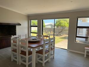 a dining room with a table and chairs and a fireplace at Dutchie - 4 Vygie Avenue in Struisbaai