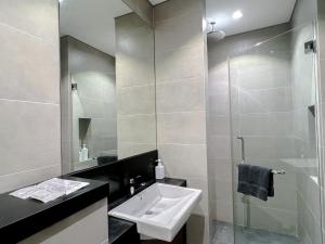 W łazience znajduje się umywalka i przeszklony prysznic. w obiekcie 8 Kia Peng Residence Kuala Lumpur, Pavillion by Scape Stay w Kuala Lumpur