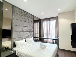 a bedroom with a large white bed and a television at 8 Kia Peng Residence Kuala Lumpur, Pavillion by Scape Stay in Kuala Lumpur