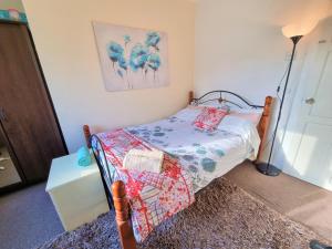 ein kleines Schlafzimmer mit einem Bett mit einer Decke darauf in der Unterkunft London Rooms in London
