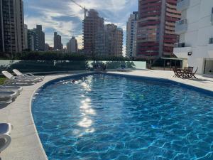 a large swimming pool with chairs and buildings at Torre Marina II Punta del Este in Punta del Este